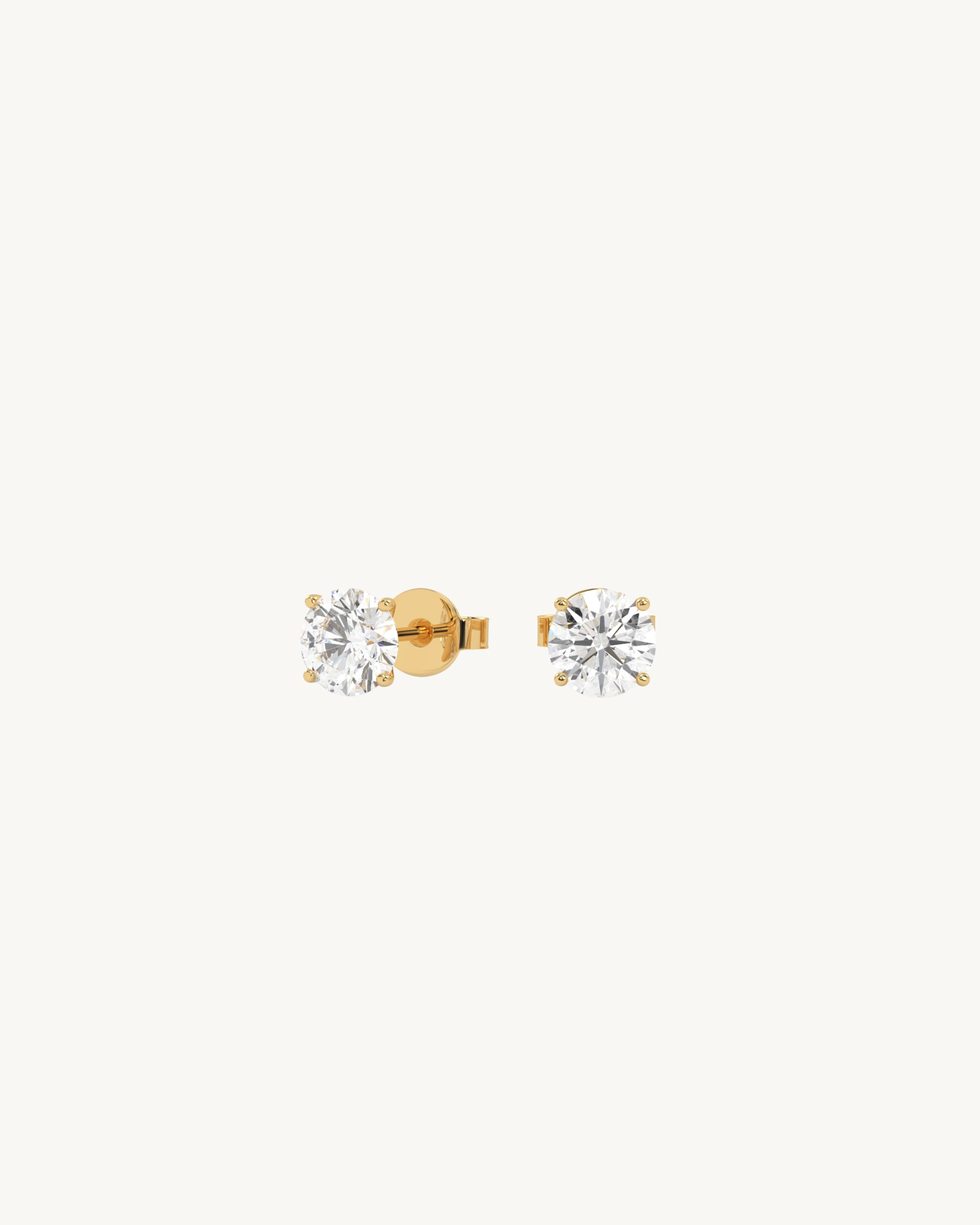 Pair of gold and diamond stud earrings on a white background
