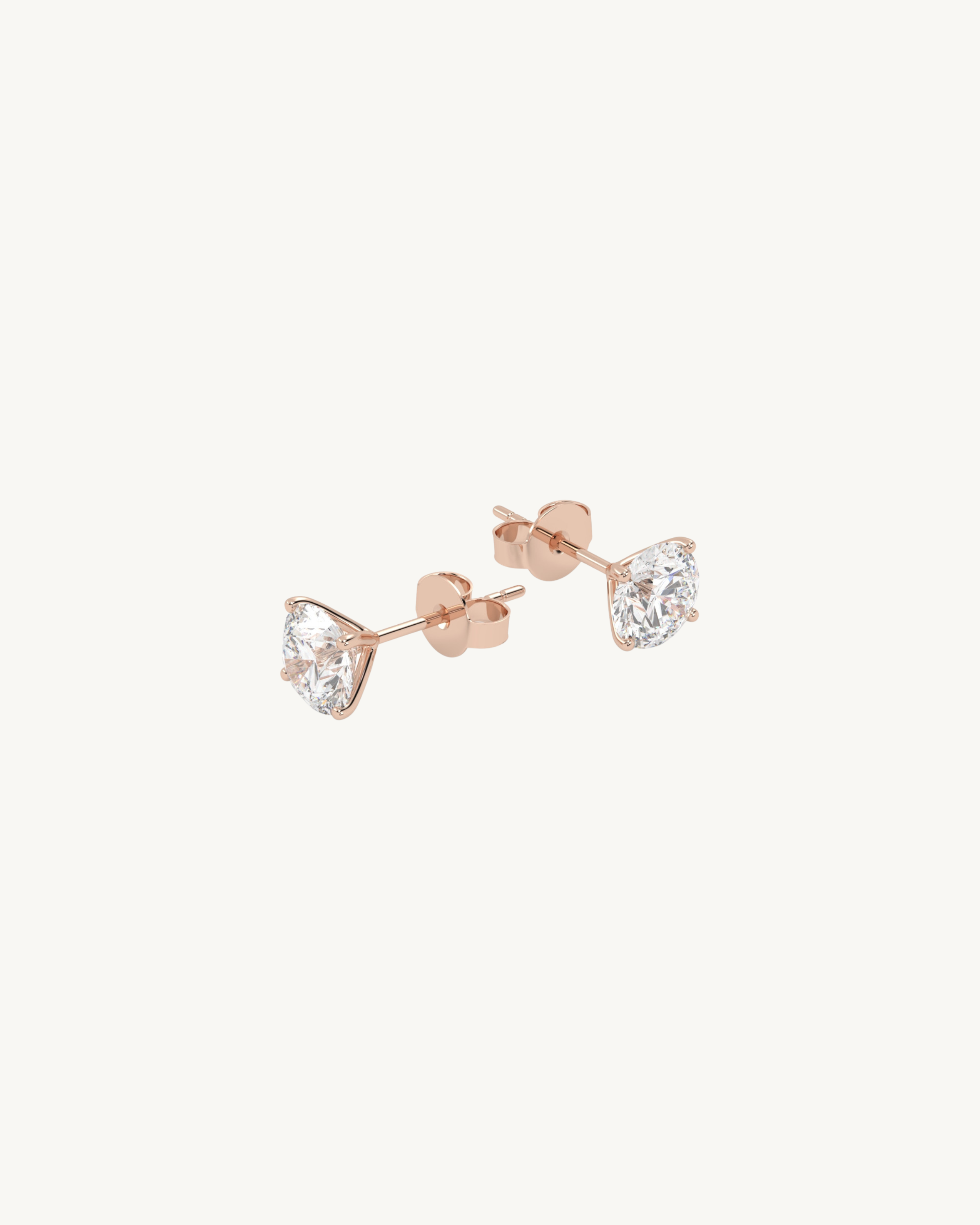 Rose gold round shaped stud earrings on a white background