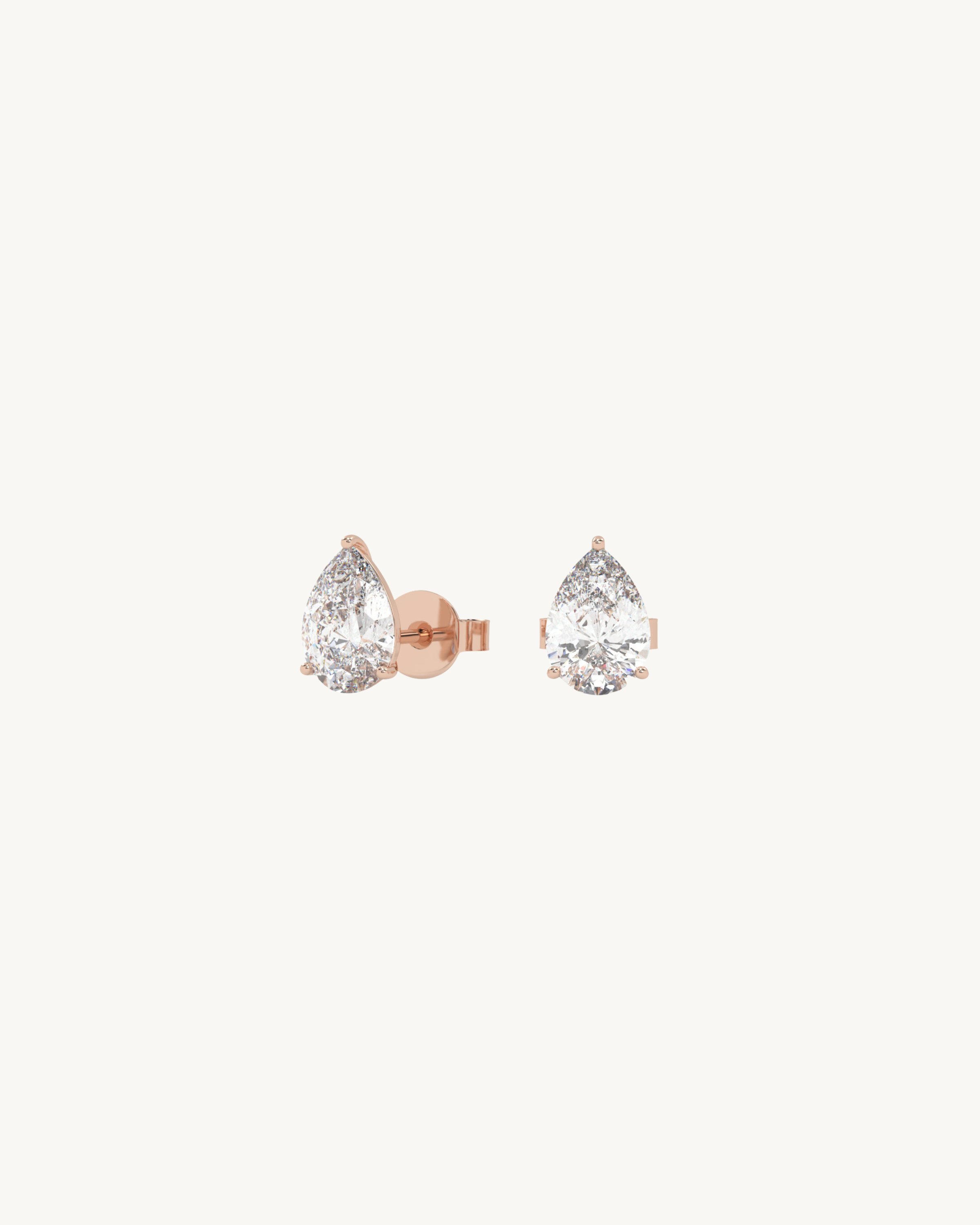 Pair of teardrop-shaped earrings with rose gold setting on a white background