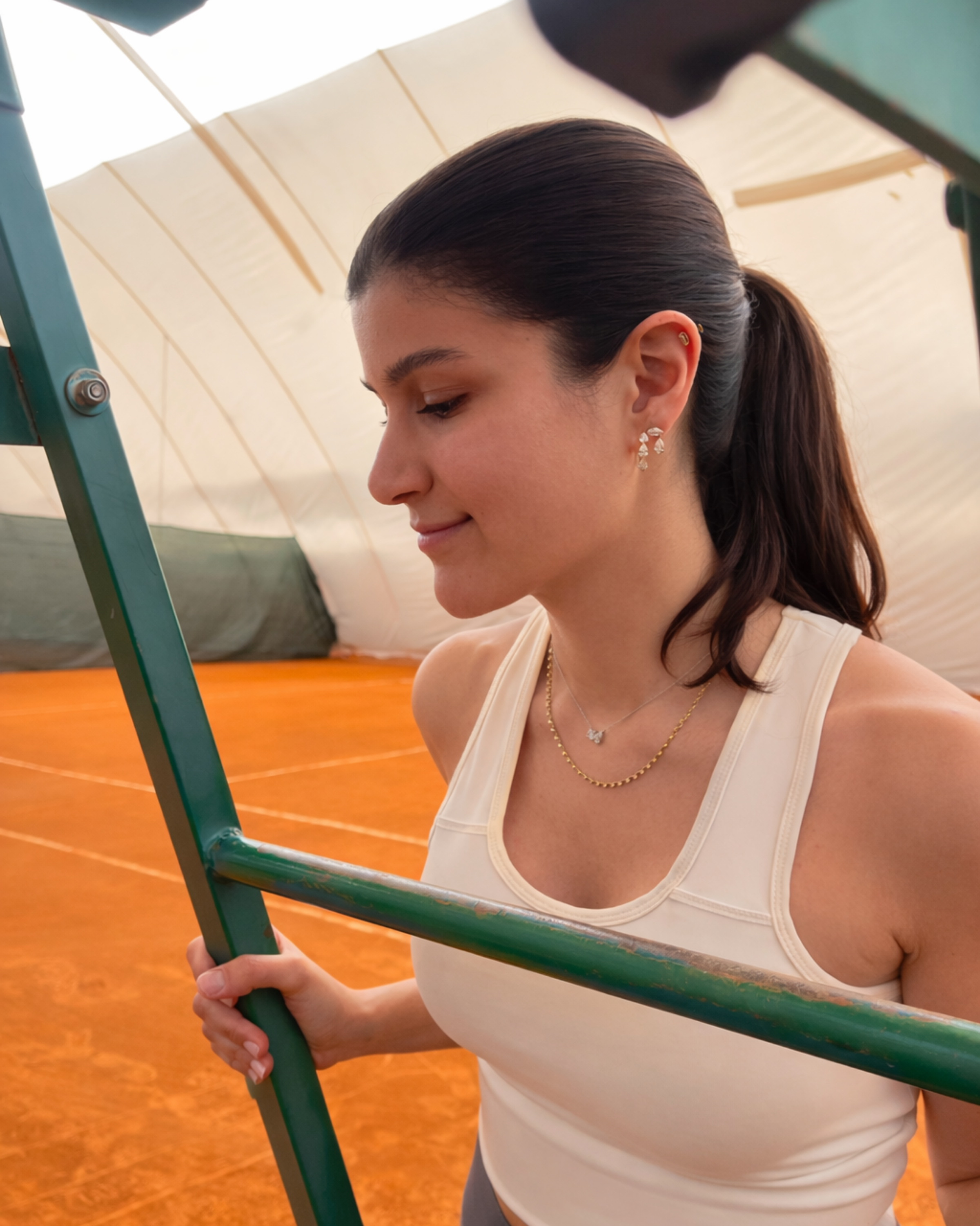 woman playing tennis with diamond earrings in gold with diamonds