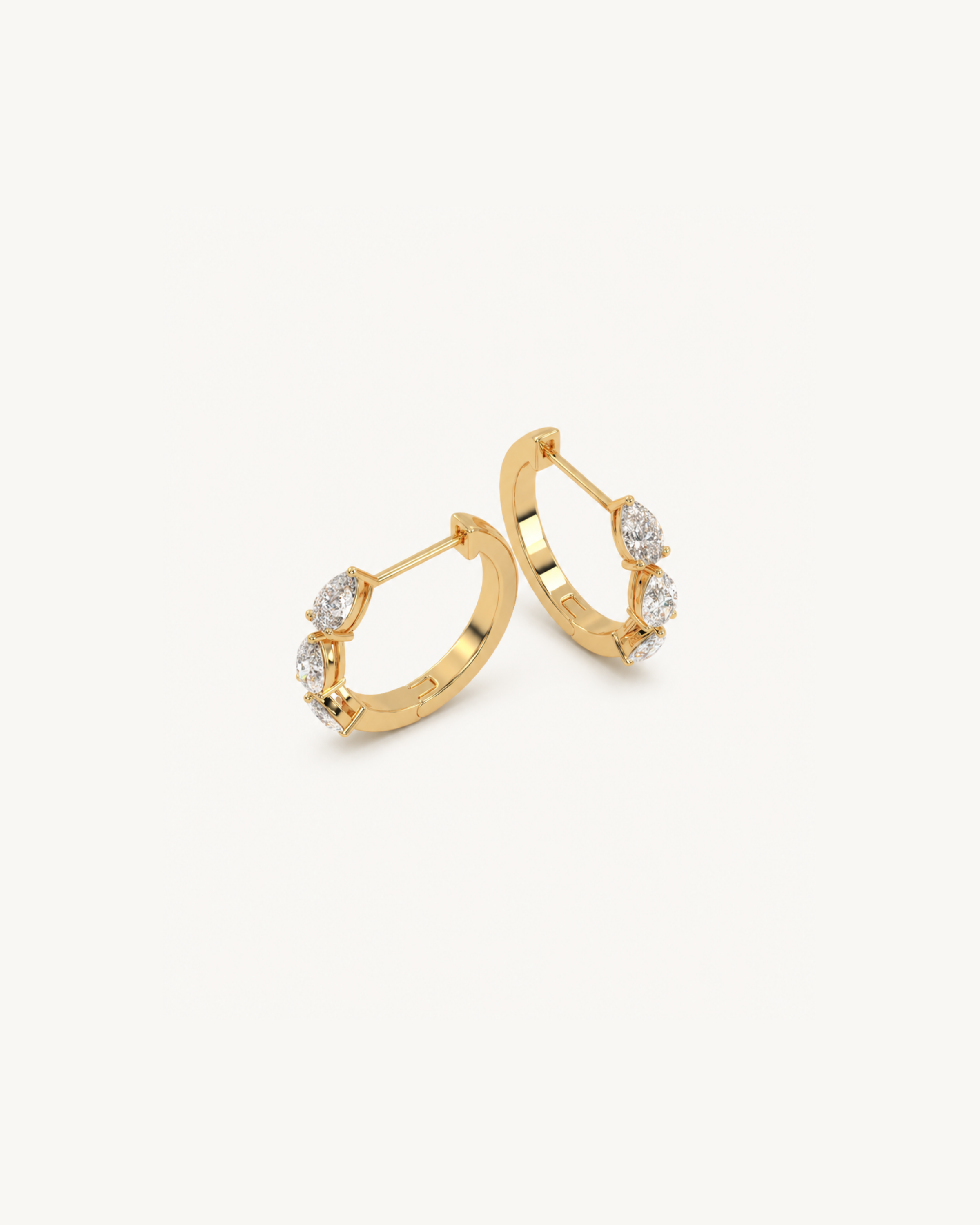 Gold hoop earrings with small diamonds on a white background